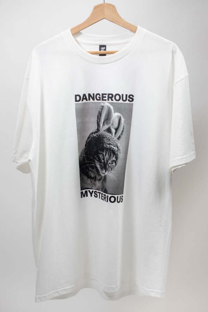 White t-shirt with a cat in bunny ear that reads DANGEROUS MYSTERIOUS