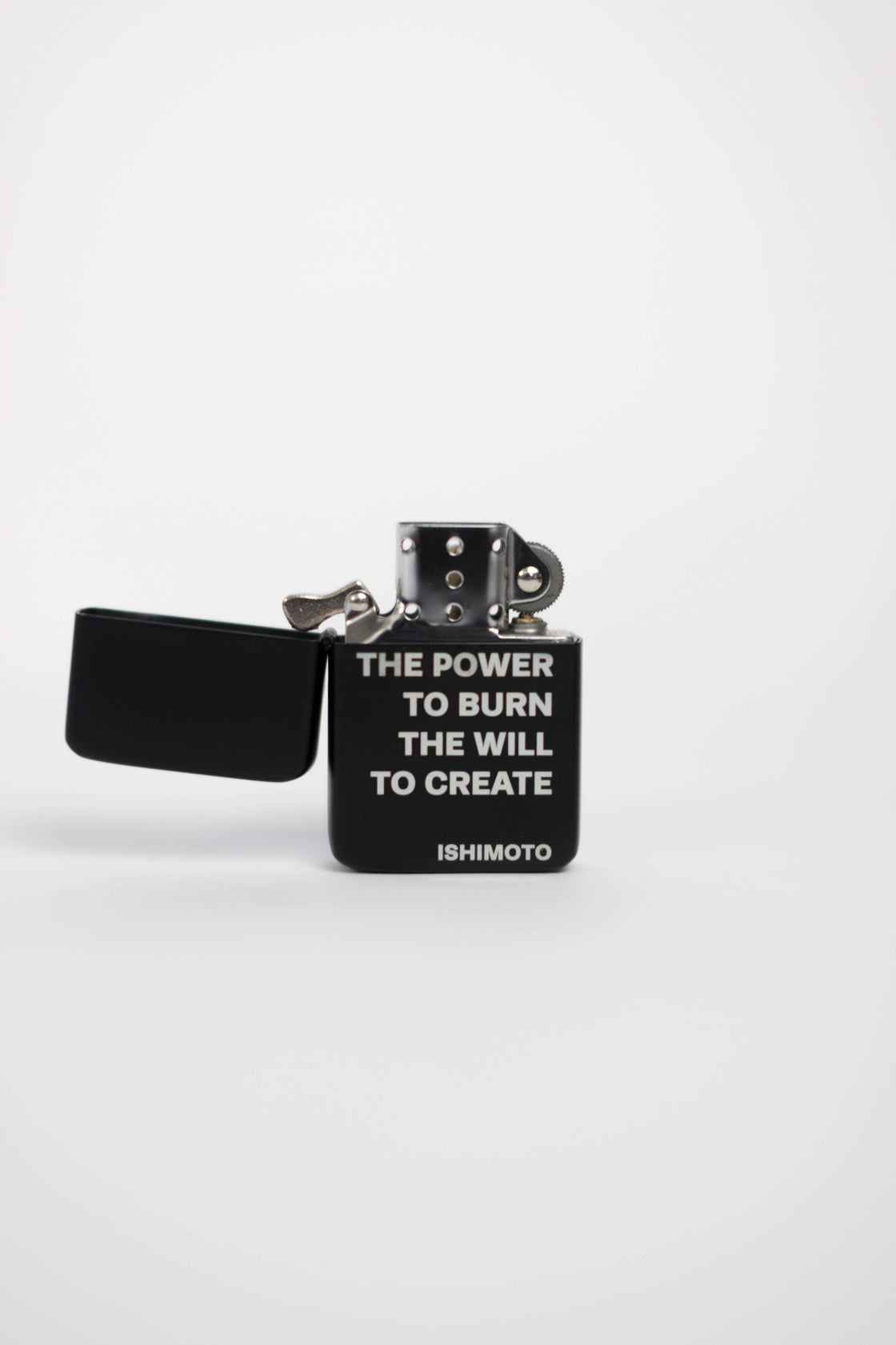 Black lighter engraved with "THE POWER TO BURN THE POWER TO CREATE"